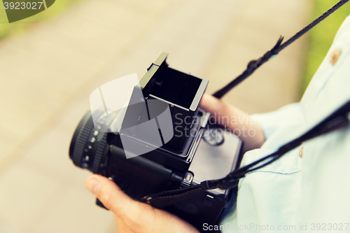 Image of close up of male photographer with digital camera