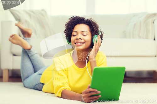 Image of happy african woman with tablet pc and headphones