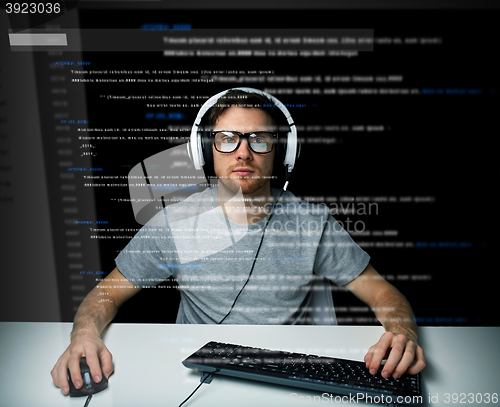 Image of man in headset hacking computer or programming