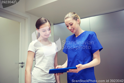 Image of smiling nurse with tablet pc and girl at hospital