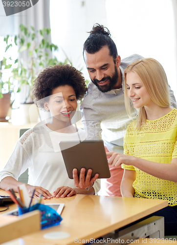 Image of happy creative team with tablet pc in office