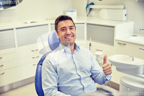 Image of happy man showing thumbs up at dental clinic