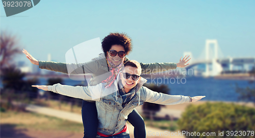 Image of happy teenage couple in shades having fun outdoors