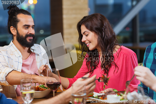 Image of friends eating and tasting food at restaurant