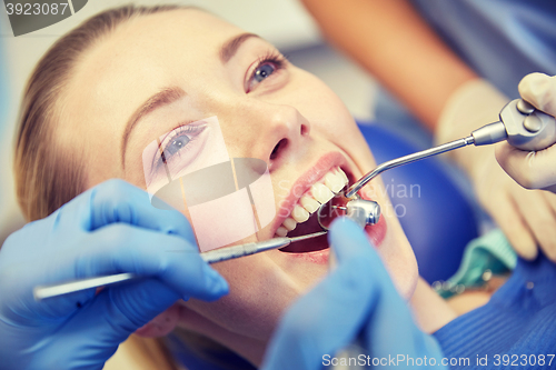 Image of close up of dentist treating female patient teeth