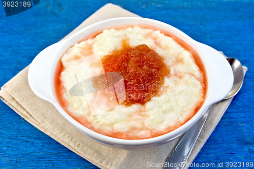 Image of Rice porridge with jam in bowl on blue board