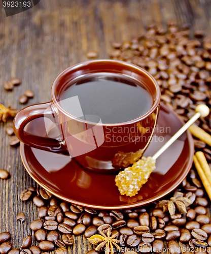 Image of Coffee in brown cup with sugar and star anise on board