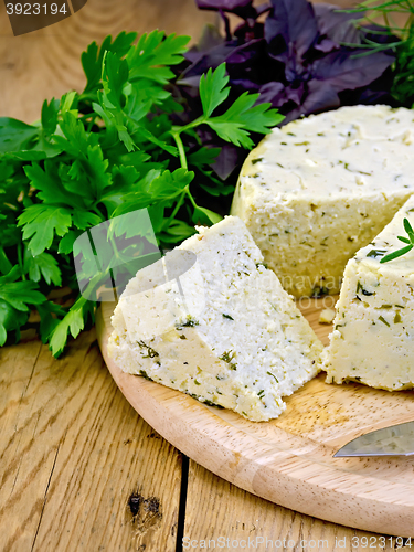 Image of Cheese homemade round with herbs on board