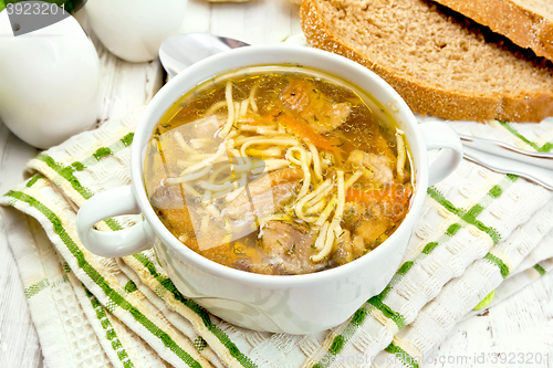 Image of Soup with mushrooms and noodles in bowl on napkin
