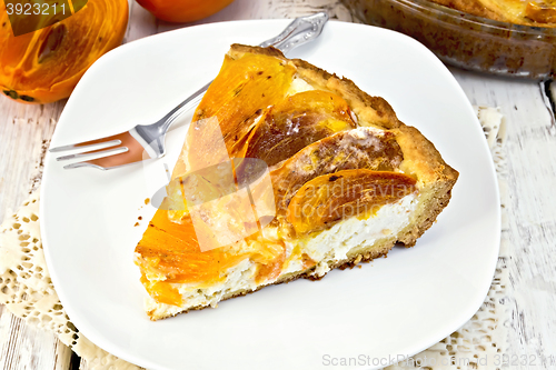 Image of Pie with curd and persimmons with fork in plate on board