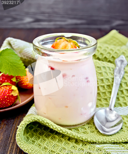 Image of Yogurt with strawberries in jar on napkin