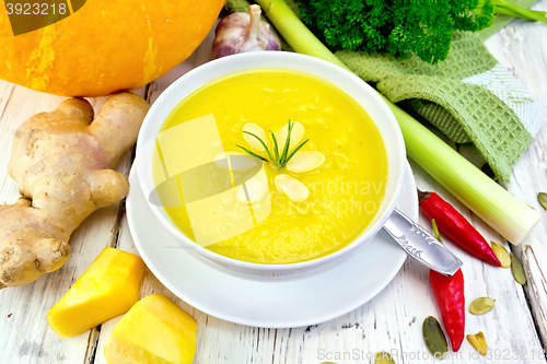 Image of Soup-puree pumpkin with rosemary in white bowl on board