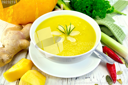 Image of Soup-puree pumpkin with rosemary in bowl on board