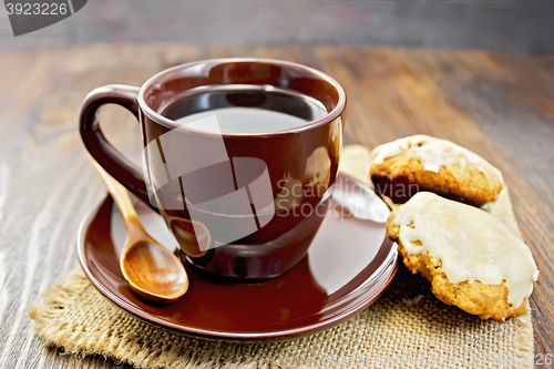 Image of Coffee in brown cup with cookies on board