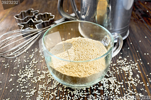 Image of Flour sesame in cup with sieve and mixer on board