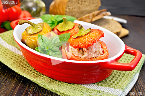 Image of Pepper stuffed meat in red roaster on dark board