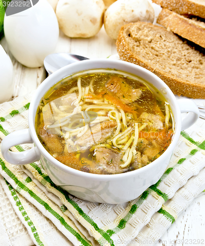 Image of Soup with mushrooms and noodles in bowl on light board