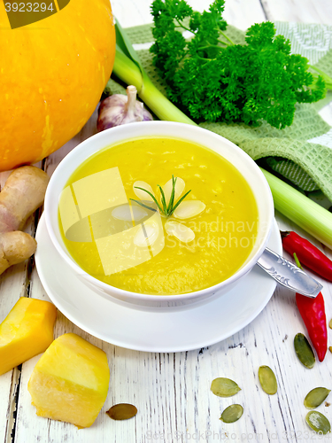 Image of Soup-puree pumpkin with almonds in bowl on board