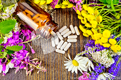 Image of Capsules in brown jar with flowers on board top