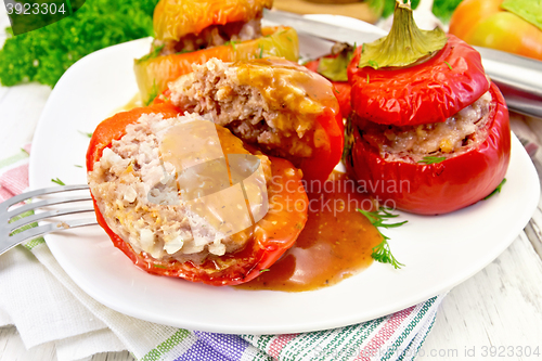 Image of Pepper stuffed meat and rice with sauce in plate on table