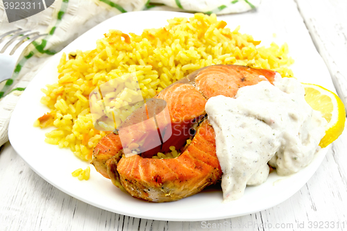 Image of Salmon with sauce and rice on board