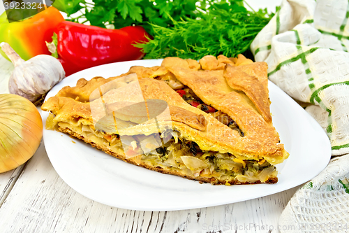 Image of Pie with cabbage and sorrel in plate on light board