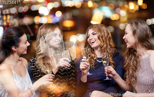 Image of happy women with champagne glasses at night club