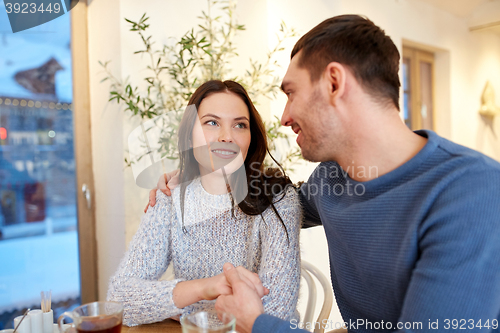 Image of happy couple drinking tea at restaurant