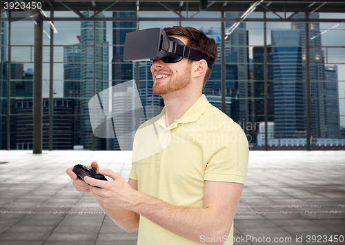 Image of happy man in virtual reality headset with gamepad