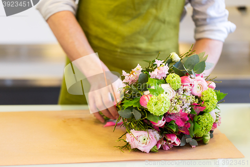 Image of florist wrapping flowers in paper at flower shop