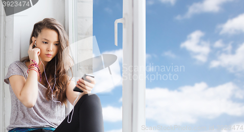 Image of teenage girl with smartphone and earphones