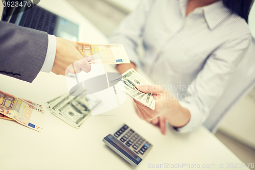 Image of close up of hands giving or exchanging money