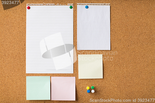 Image of close up of blank stickers and paper on cork board