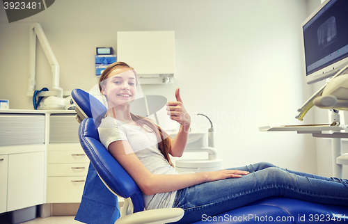 Image of happy patient girl showing thumbs up at clinic