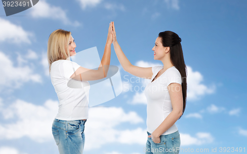 Image of group of happy different women in white t-shirts