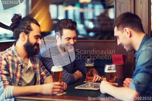 Image of male friends with tablet pc drinking beer at bar