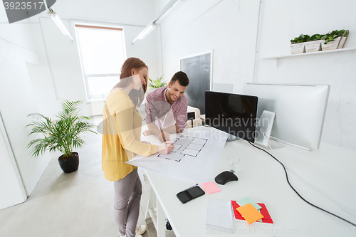 Image of creative team with blueprint working at office