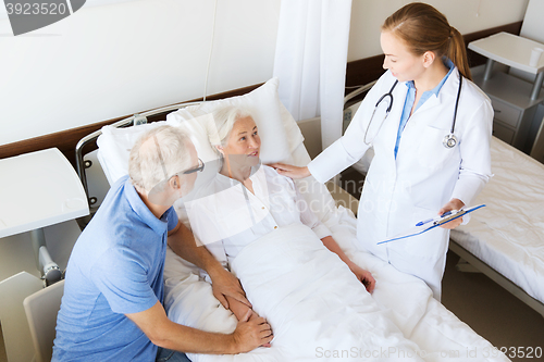 Image of senior woman and doctor with clipboard at hospital