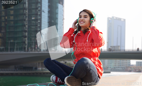 Image of happy young woman in headphones listening to music