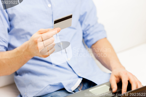 Image of close up of man with laptop and credit card