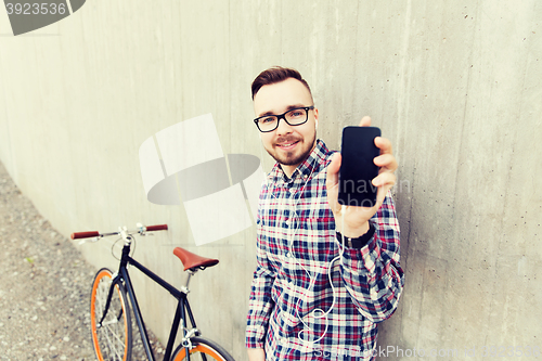 Image of hipster man in earphones with smartphone and bike