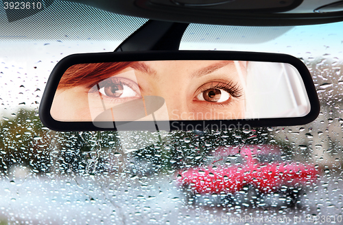 Image of woman looks to rear-view mirror