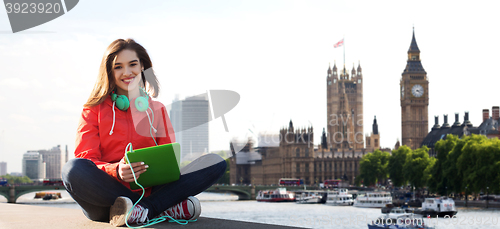 Image of happy young woman with tablet pc and headphones