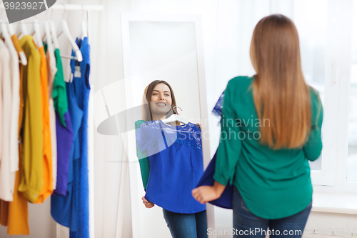 Image of happy woman choosing clothes at home wardrobe