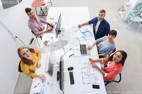 Image of creative team with computers, blueprint at office