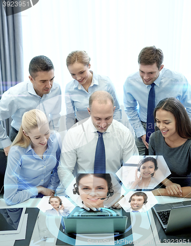 Image of smiling business people with laptop in office