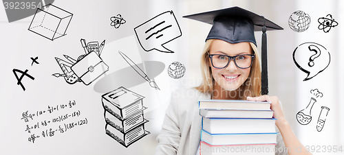 Image of happy student woman in mortarboard with books