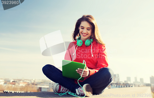 Image of happy young woman with tablet pc and headphones