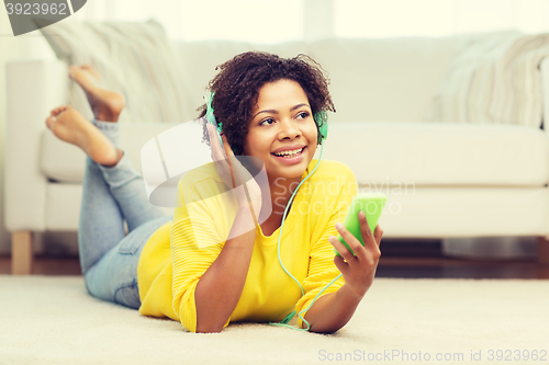 Image of happy african woman with smartphone and headphones