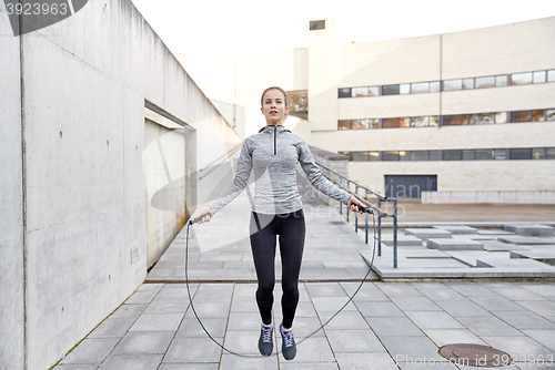 Image of woman exercising with jump-rope outdoors